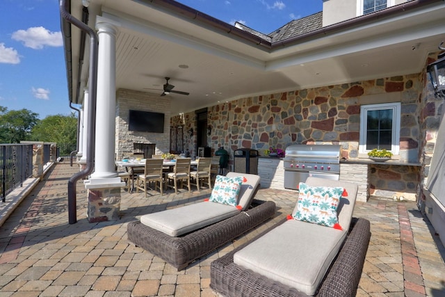 view of patio with ceiling fan, outdoor dining area, area for grilling, and an outdoor kitchen