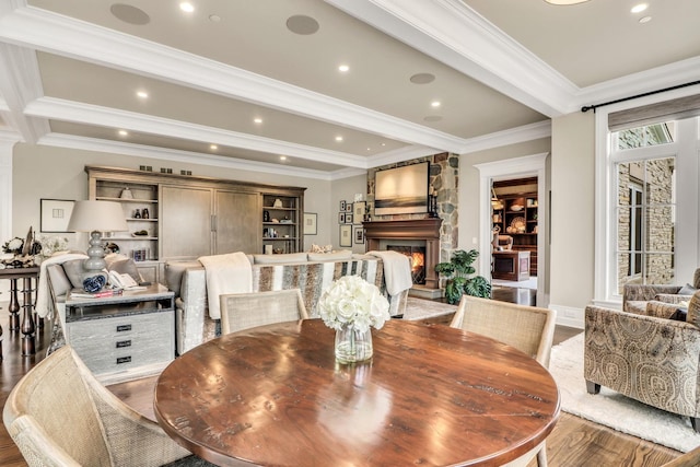 dining room with crown molding, beam ceiling, recessed lighting, a fireplace, and wood finished floors