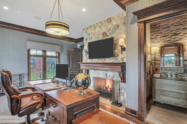 office area featuring wallpapered walls, crown molding, wood finished floors, and a large fireplace