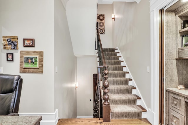 stairway featuring wood finished floors and baseboards