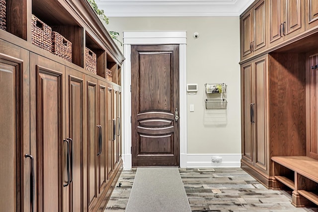 mudroom with light wood-type flooring, crown molding, and baseboards