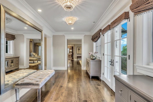 hallway featuring baseboards, ornamental molding, french doors, wood finished floors, and a notable chandelier