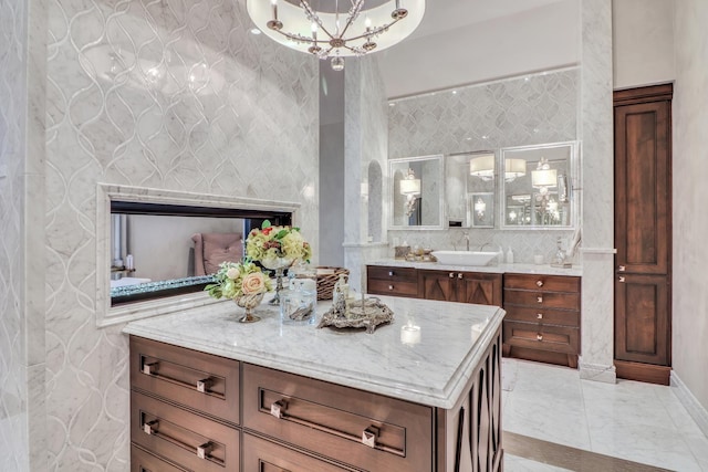 bathroom featuring vanity, a notable chandelier, and backsplash