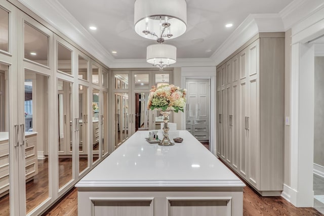 interior space with light wood-style floors, a kitchen island, and ornamental molding