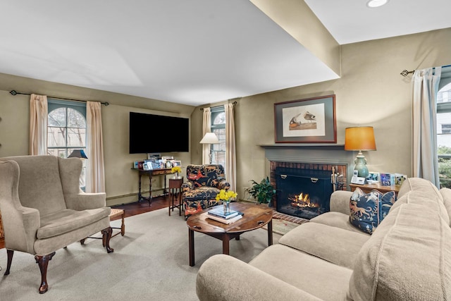 living area featuring recessed lighting, baseboard heating, wood finished floors, and a fireplace