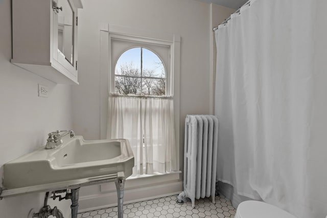 full bath with a shower with shower curtain, radiator, and toilet