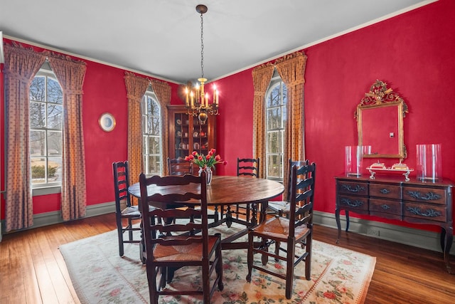 dining space featuring baseboards, a notable chandelier, and hardwood / wood-style flooring