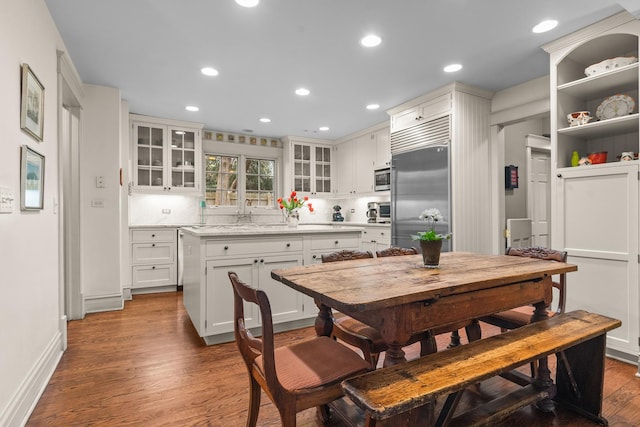 dining space with a toaster, recessed lighting, wood finished floors, and baseboards