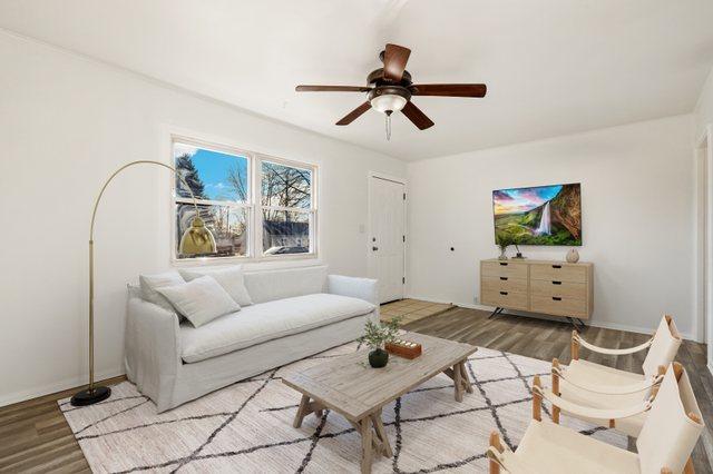 living area with wood finished floors, baseboards, and ceiling fan