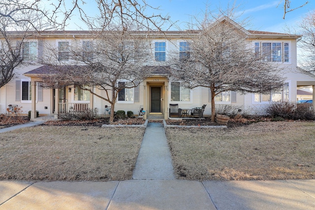 multi unit property featuring covered porch and a front yard