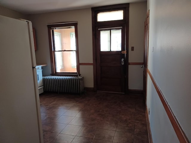 tiled foyer entrance with baseboards and radiator heating unit