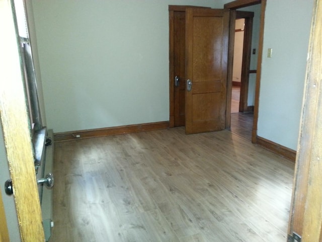 spare room with light wood finished floors and baseboards