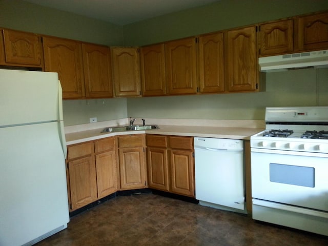 kitchen featuring white appliances, brown cabinetry, a sink, light countertops, and under cabinet range hood