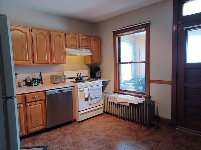 kitchen with under cabinet range hood, gas range gas stove, stainless steel dishwasher, freestanding refrigerator, and radiator