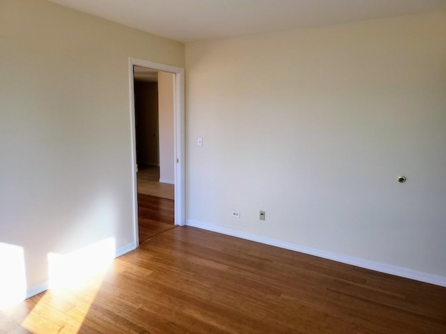 empty room with baseboards and wood finished floors