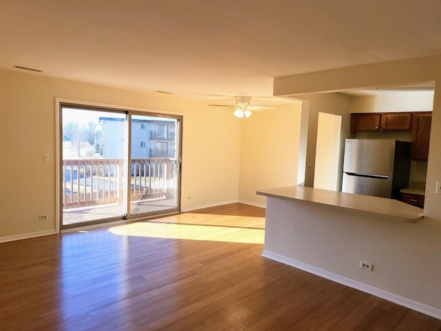 interior space with ceiling fan, baseboards, and wood finished floors