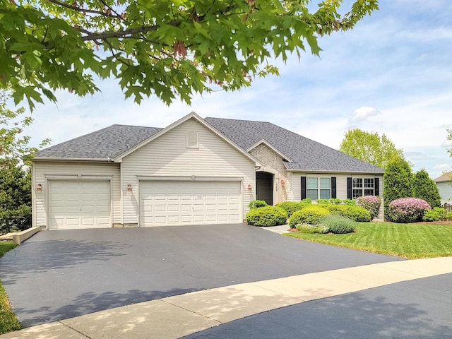 ranch-style house featuring aphalt driveway, a front lawn, roof with shingles, and an attached garage