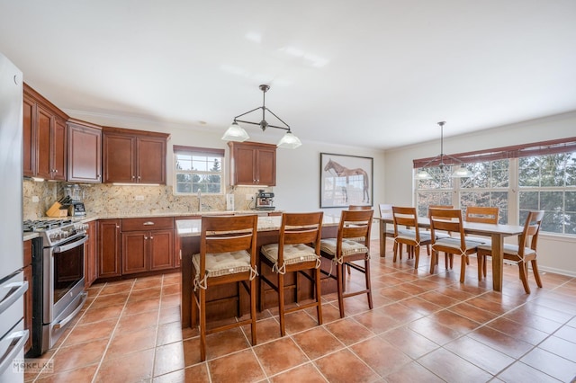 kitchen featuring decorative backsplash, stainless steel range with gas cooktop, light tile patterned flooring, and crown molding