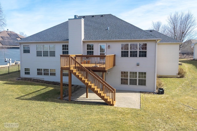 rear view of house with a patio, a wooden deck, a yard, a chimney, and stairs