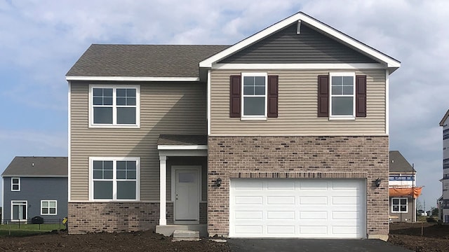 view of front of property with brick siding, an attached garage, and aphalt driveway