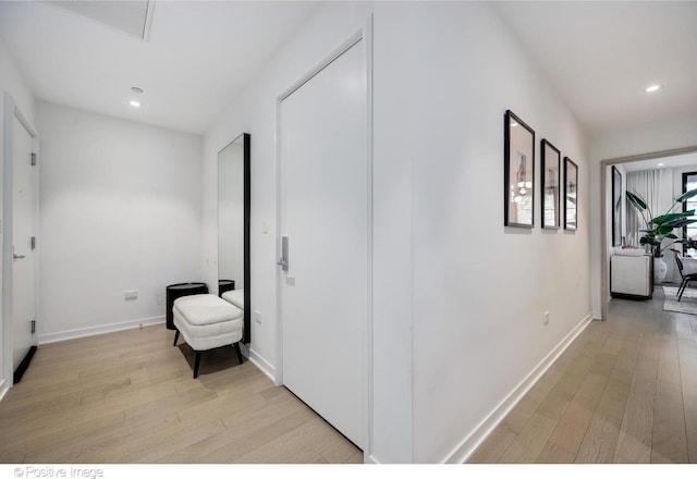 corridor featuring recessed lighting, light wood-style flooring, and baseboards