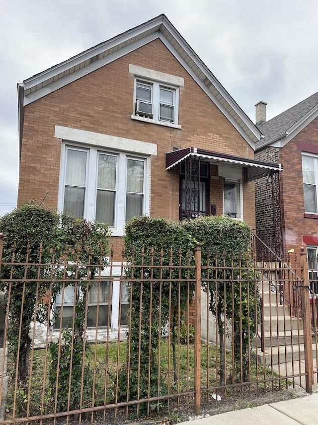 view of front of house featuring brick siding and fence