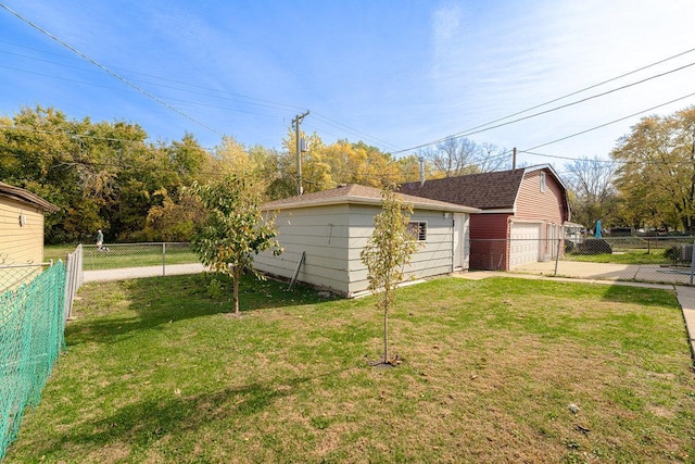 view of side of home featuring a yard, a fenced backyard, a garage, and an outdoor structure