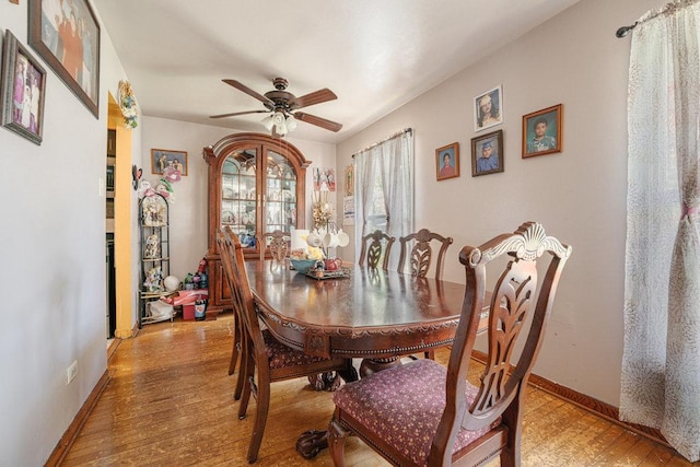 dining space with light wood-style flooring, baseboards, and ceiling fan