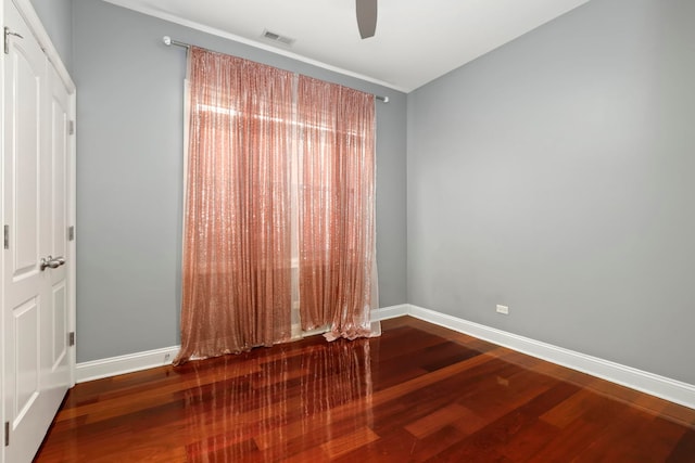 spare room with visible vents, a ceiling fan, baseboards, and wood finished floors