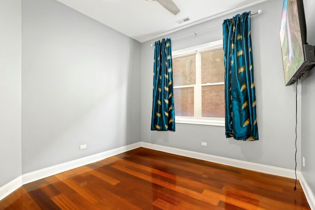 unfurnished room with visible vents, baseboards, and wood finished floors