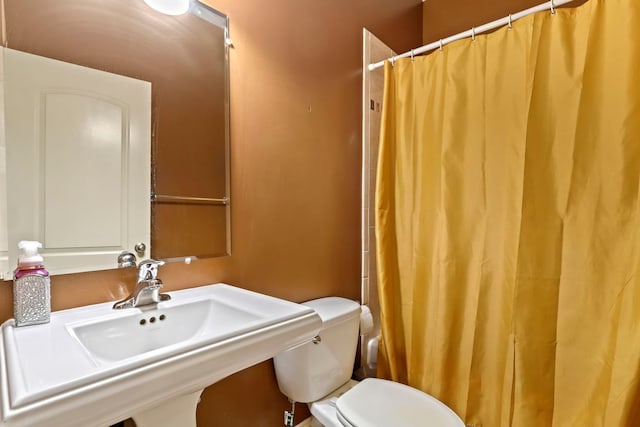 full bathroom featuring a sink, a shower with curtain, and toilet