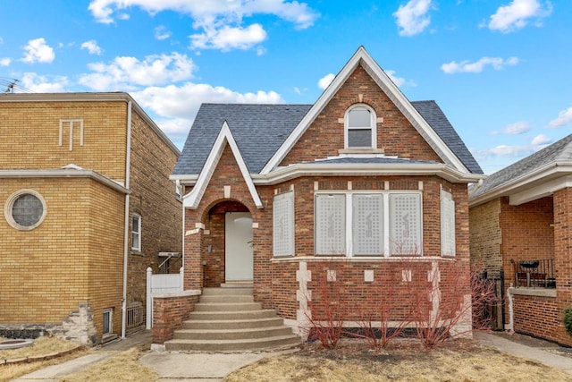 view of front of house with brick siding and a shingled roof