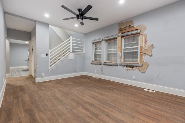 spare room with ceiling fan, stairway, baseboards, and wood finished floors