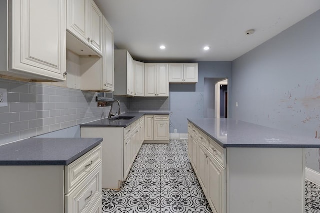 kitchen with baseboards, a kitchen island, recessed lighting, a sink, and tasteful backsplash