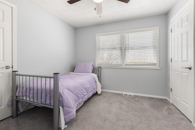 carpeted bedroom with visible vents, baseboards, and ceiling fan