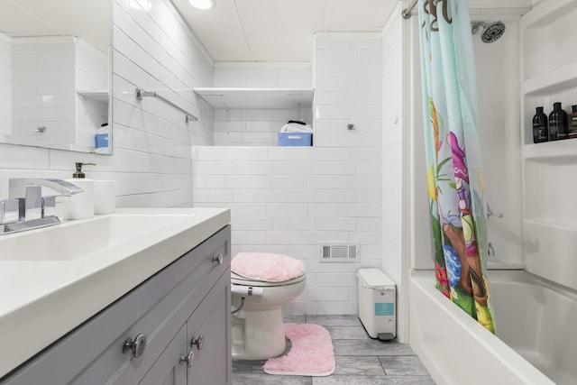 full bath with visible vents, shower / bath combo with shower curtain, toilet, tile walls, and vanity