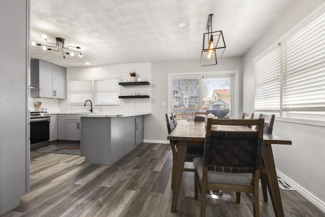 dining space featuring dark wood-type flooring and baseboards