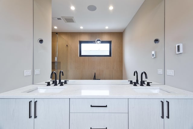 bathroom with double vanity, a sink, and visible vents