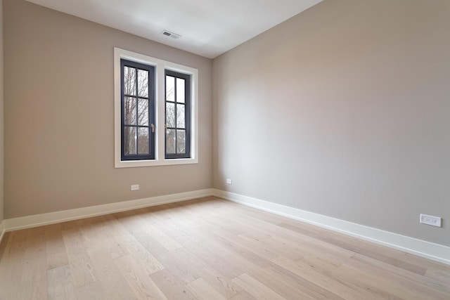 spare room with visible vents, baseboards, and light wood-style floors