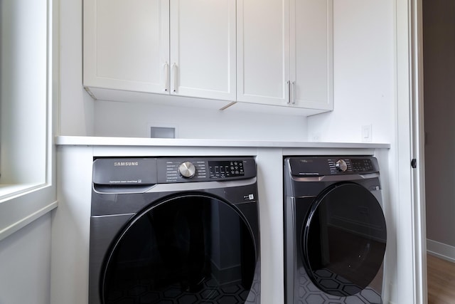 laundry area with washing machine and clothes dryer and cabinet space