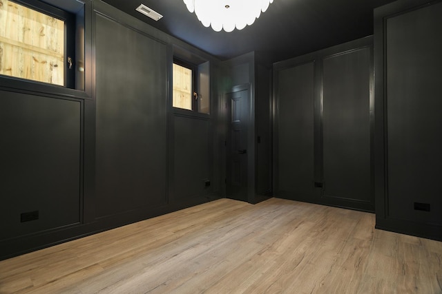 unfurnished room with light wood-type flooring and visible vents