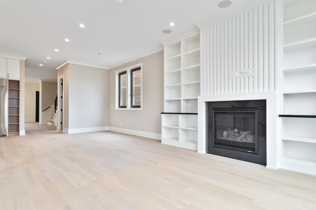 unfurnished living room featuring baseboards, built in shelves, ornamental molding, recessed lighting, and a glass covered fireplace
