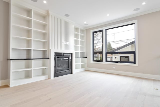 unfurnished living room featuring light wood-type flooring, baseboards, and built in shelves