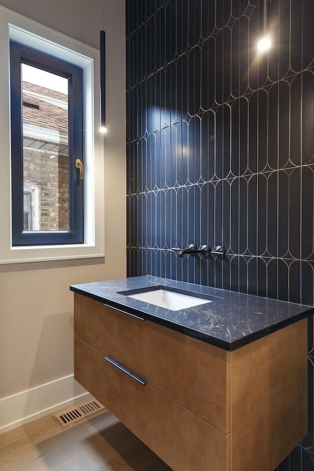 bathroom featuring baseboards, a sink, and visible vents