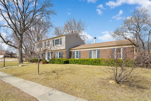 colonial home featuring brick siding and a front lawn