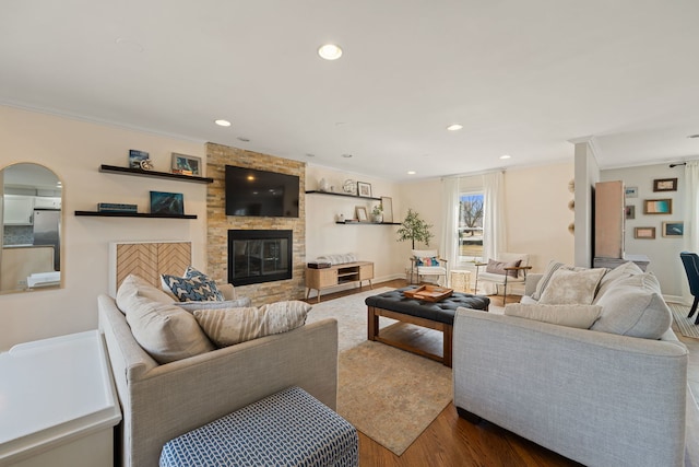 living area with dark wood-type flooring, crown molding, recessed lighting, a fireplace, and arched walkways