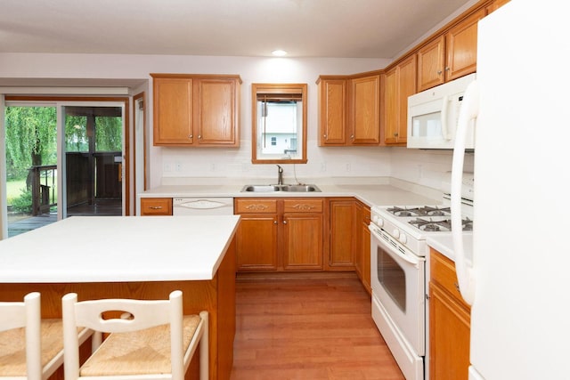 kitchen featuring plenty of natural light, white appliances, light countertops, and a sink