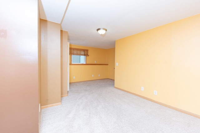 empty room with baseboards and light colored carpet