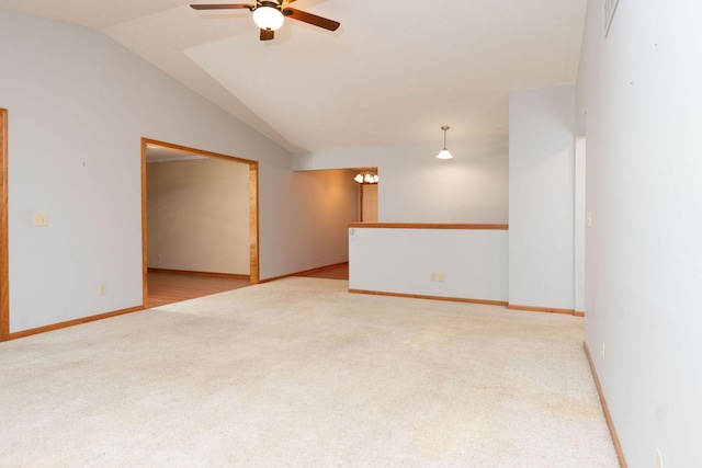 empty room with lofted ceiling, carpet, baseboards, and ceiling fan