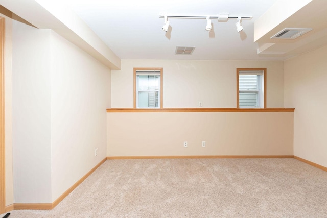 carpeted spare room featuring baseboards and visible vents